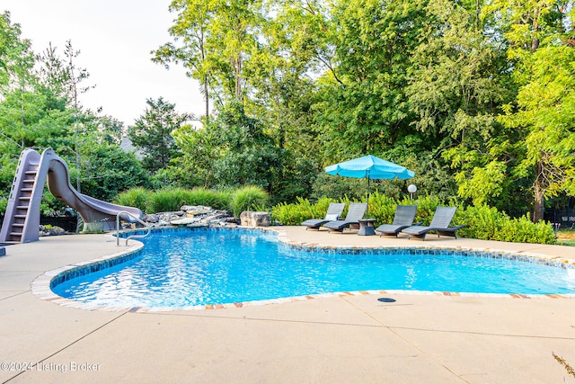 view of pool with a patio area and a water slide