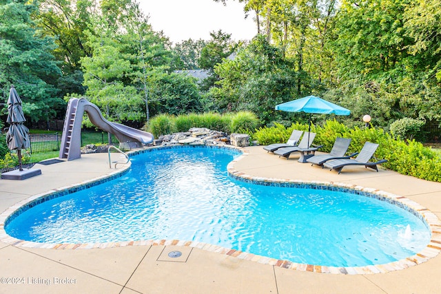 view of pool featuring a patio area and a water slide