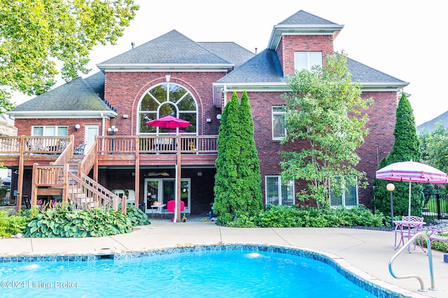 back of property with a pool side deck and a patio area