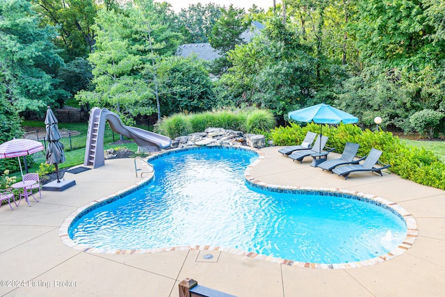 view of swimming pool featuring a patio area and a water slide