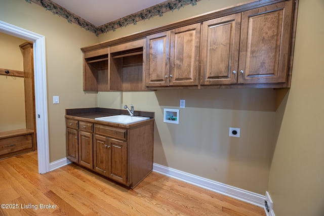 laundry room featuring electric dryer hookup, cabinets, sink, hookup for a washing machine, and light hardwood / wood-style floors