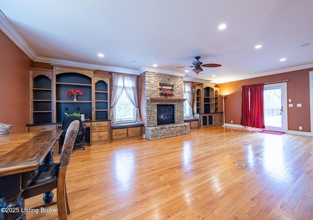 interior space featuring ceiling fan, a fireplace, light hardwood / wood-style floors, and ornamental molding