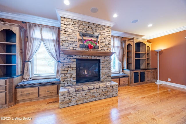 living room with ornamental molding, a fireplace, and light hardwood / wood-style flooring