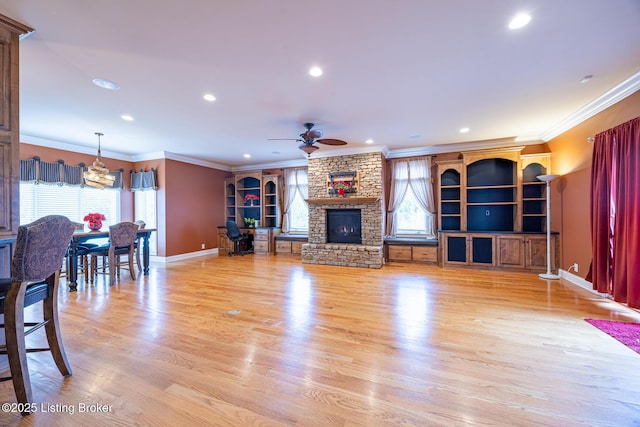 living room featuring a wealth of natural light, ceiling fan, ornamental molding, and light wood-type flooring