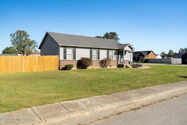 ranch-style home with a fire pit and a front lawn