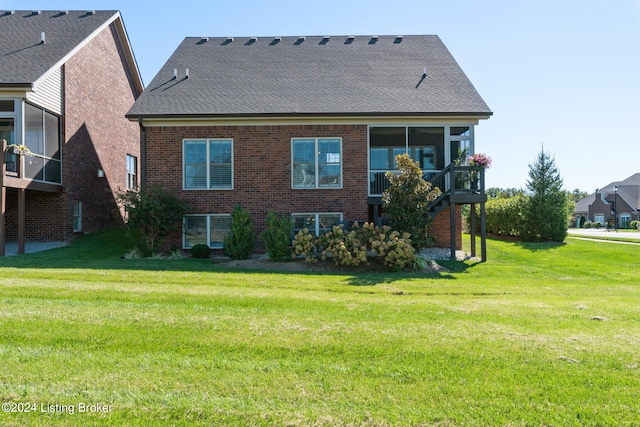 back of property featuring a sunroom and a lawn