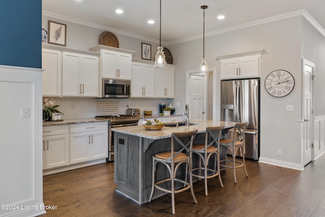 kitchen with a center island with sink, sink, light stone counters, stainless steel appliances, and white cabinetry