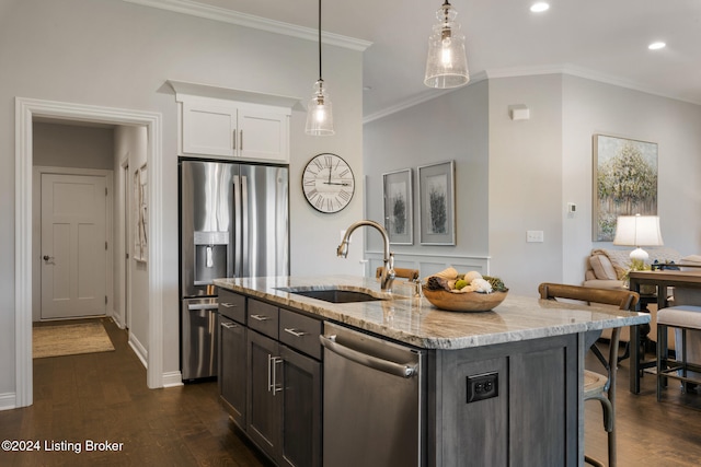 kitchen with dark hardwood / wood-style floors, sink, white cabinetry, appliances with stainless steel finishes, and a center island with sink