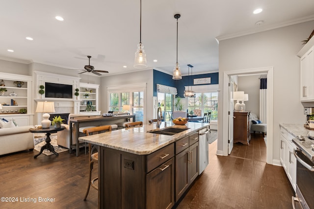 kitchen with light stone counters, stainless steel appliances, white cabinets, sink, and dark hardwood / wood-style flooring