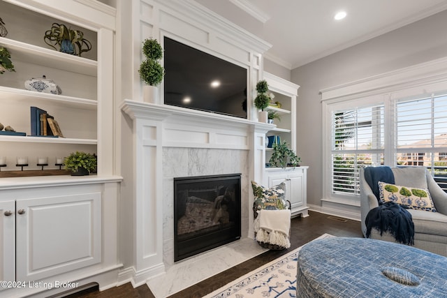 living room with dark hardwood / wood-style floors, crown molding, and a premium fireplace