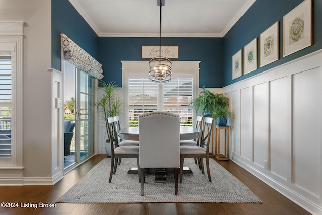 dining area featuring an inviting chandelier, crown molding, and dark hardwood / wood-style flooring