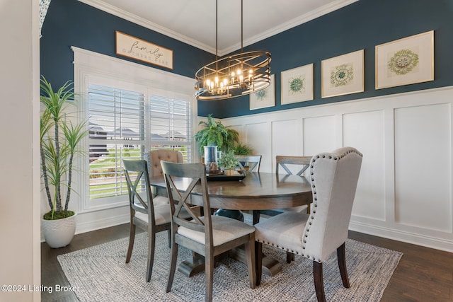 dining space with dark wood-type flooring, ornamental molding, and an inviting chandelier