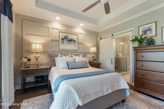 bedroom featuring ceiling fan, crown molding, and a barn door