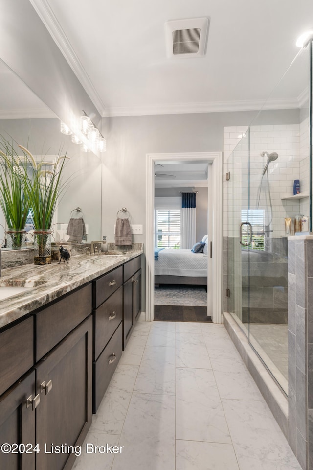 bathroom with vanity, crown molding, and a shower with door