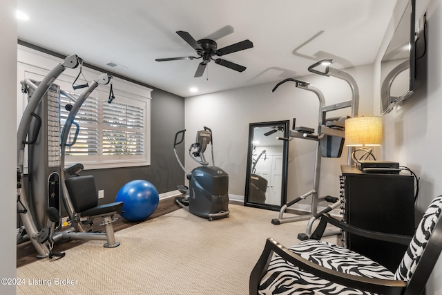 exercise room with light carpet and ceiling fan