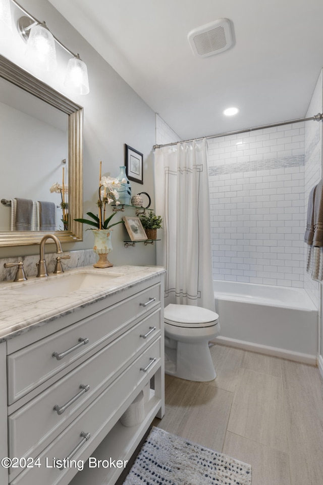 full bathroom featuring vanity, shower / tub combo with curtain, and toilet