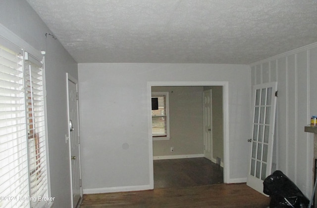 unfurnished room with wood-type flooring, a textured ceiling, and plenty of natural light