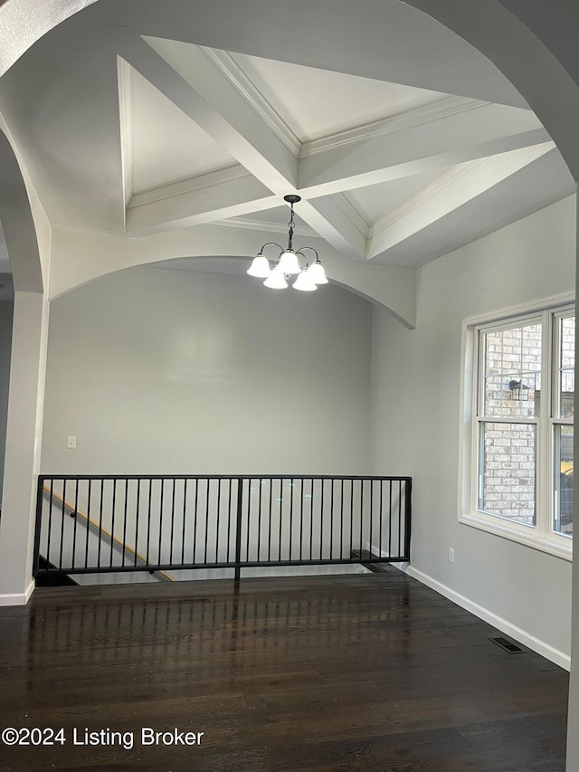 unfurnished room with dark wood-type flooring, coffered ceiling, a chandelier, ornamental molding, and beam ceiling