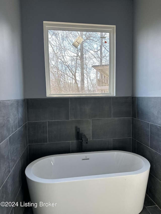 bathroom featuring a bathing tub and tile walls