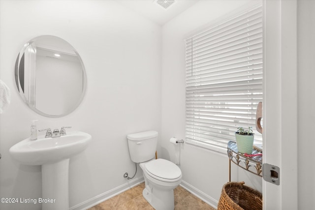 bathroom with toilet and tile patterned floors