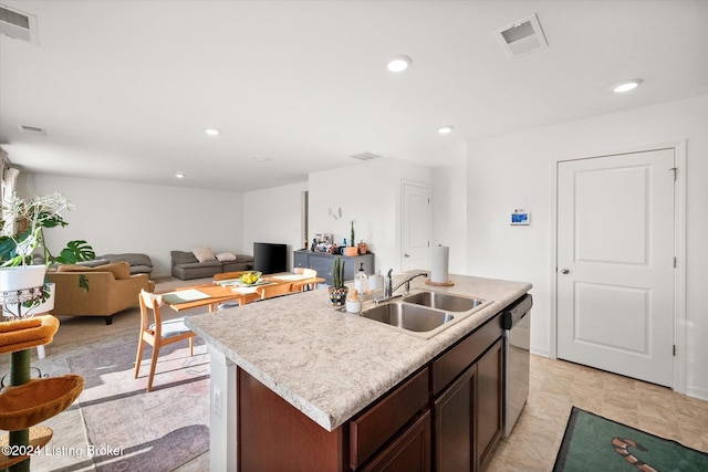 kitchen featuring an island with sink, dark brown cabinetry, stainless steel dishwasher, and sink