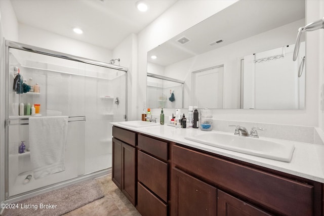 bathroom with tile patterned flooring, walk in shower, and vanity