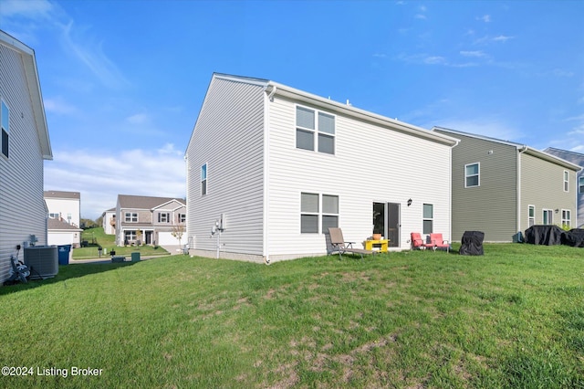 rear view of house featuring a yard and central air condition unit