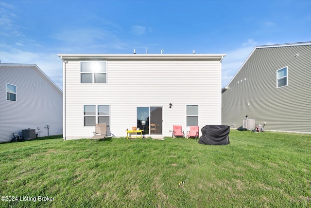 rear view of house with a yard and central AC