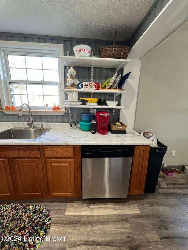 kitchen with a textured ceiling, dishwasher, wood-type flooring, and sink