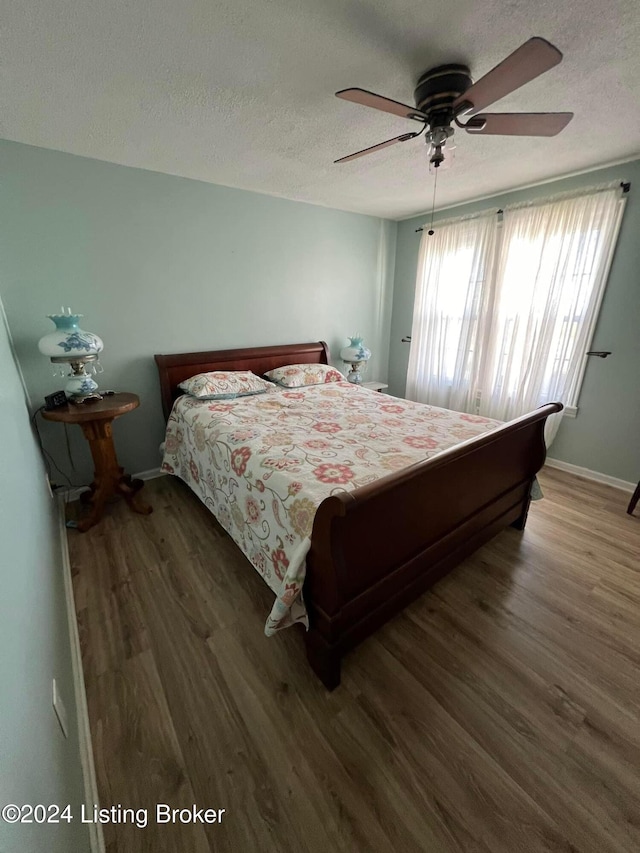 bedroom featuring a textured ceiling, dark hardwood / wood-style flooring, and ceiling fan