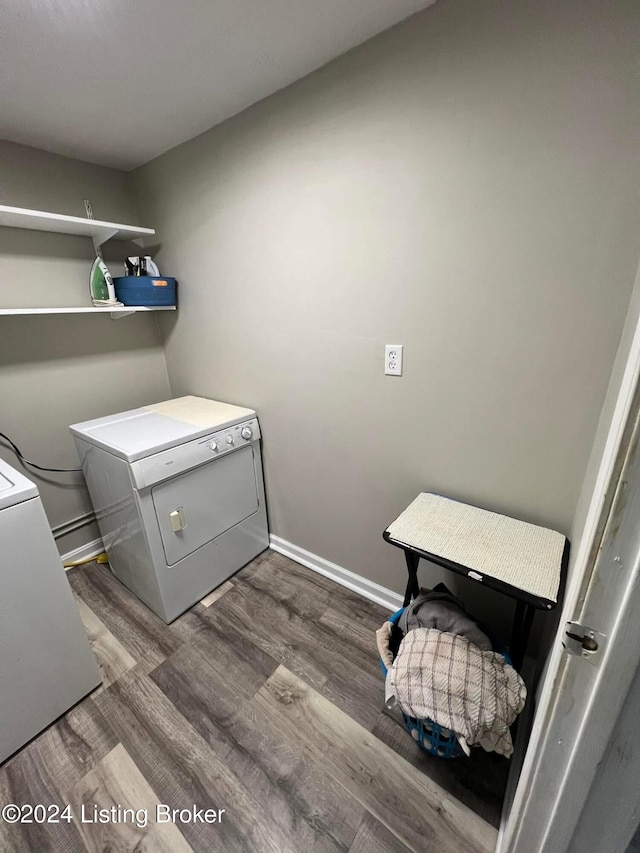 clothes washing area with dark hardwood / wood-style flooring and washing machine and clothes dryer