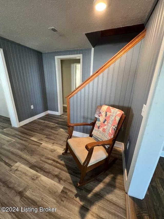 sitting room with a textured ceiling and dark wood-type flooring