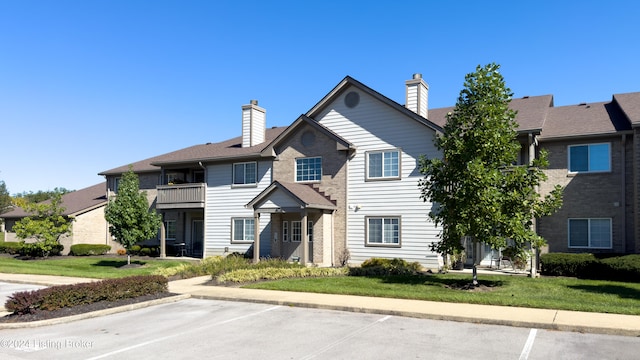 view of front of property with a front lawn and a balcony