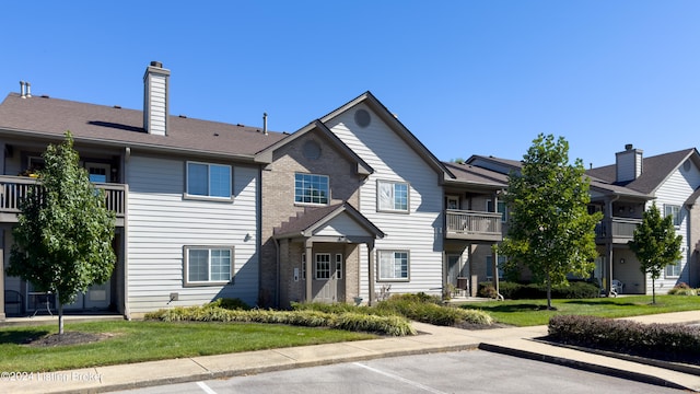 view of front of home featuring a front lawn and a balcony