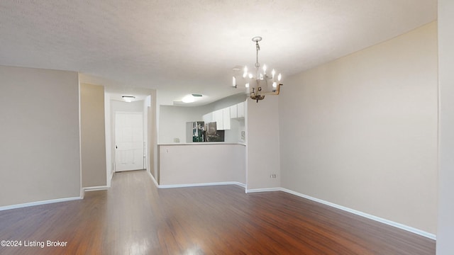 interior space featuring a textured ceiling, dark hardwood / wood-style floors, and a chandelier