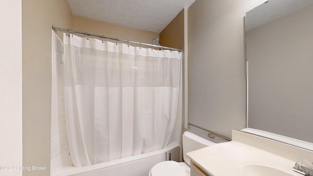 full bathroom with shower / bath combination with curtain, a textured ceiling, vanity, and toilet