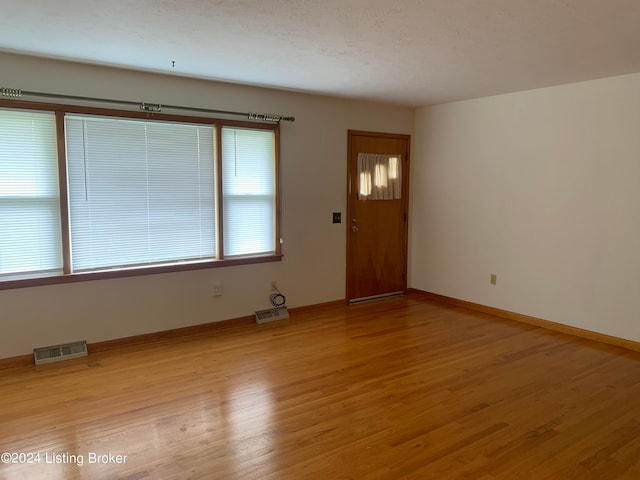 interior space featuring a textured ceiling and light hardwood / wood-style flooring