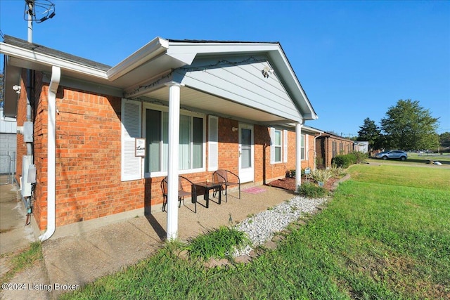 view of side of property with a yard and a patio area