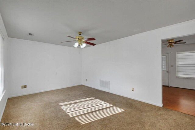 carpeted empty room with crown molding and ceiling fan