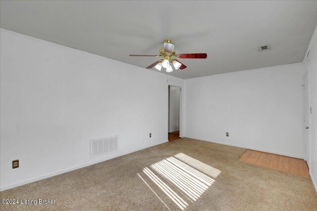 empty room featuring light colored carpet and ceiling fan