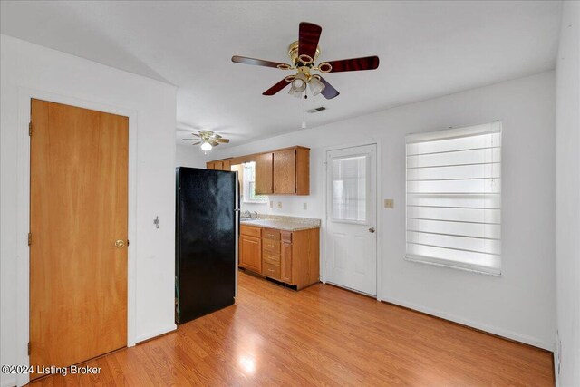 kitchen with ceiling fan, light hardwood / wood-style flooring, and black refrigerator