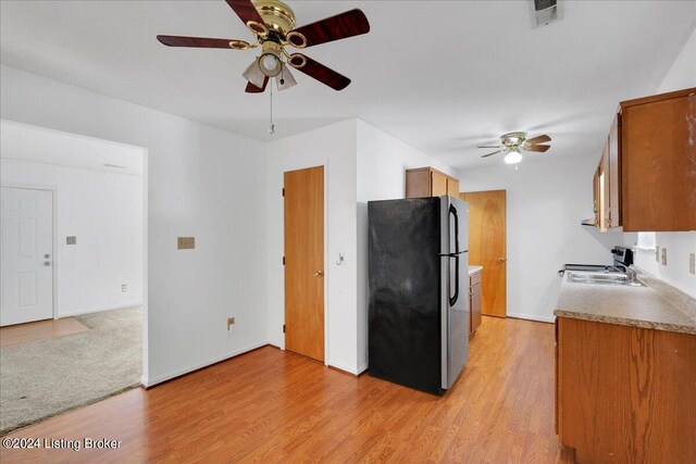 kitchen featuring ceiling fan, appliances with stainless steel finishes, and light hardwood / wood-style flooring