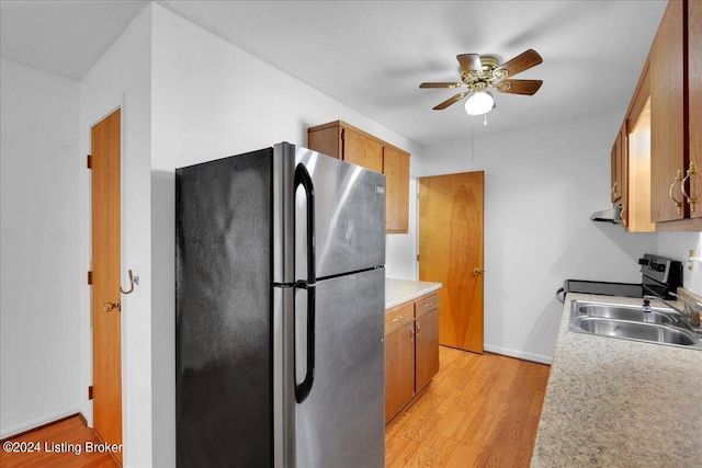 kitchen with ceiling fan, light hardwood / wood-style flooring, range hood, sink, and appliances with stainless steel finishes