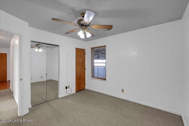 unfurnished bedroom featuring ceiling fan, a closet, and light colored carpet