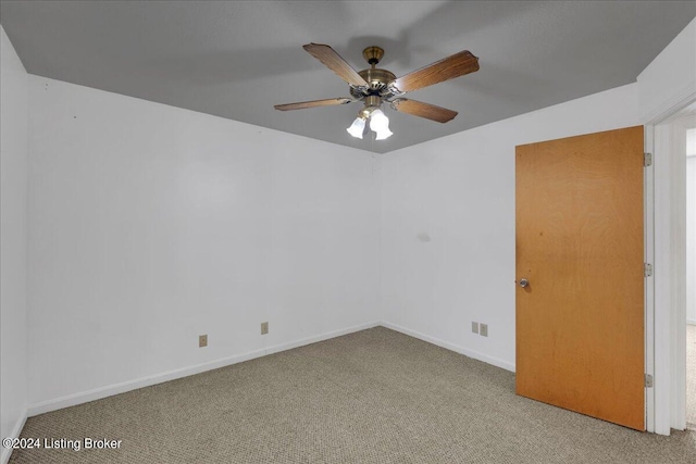 carpeted spare room with ceiling fan