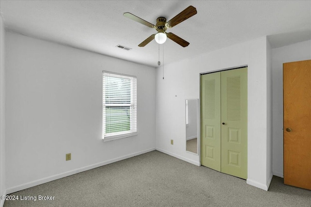 unfurnished bedroom with light carpet, ceiling fan, and a closet