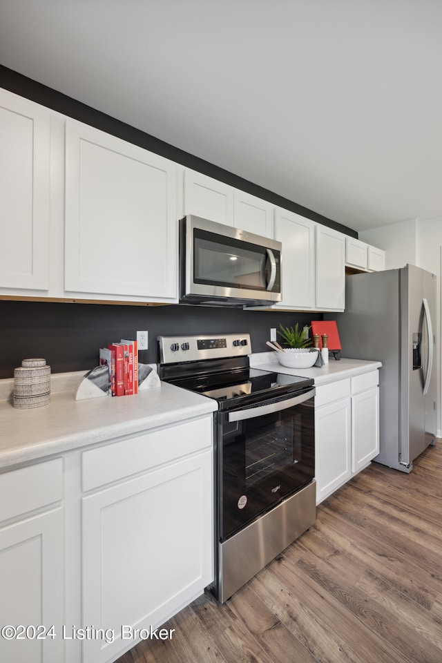 kitchen featuring white cabinets, appliances with stainless steel finishes, and dark wood-type flooring