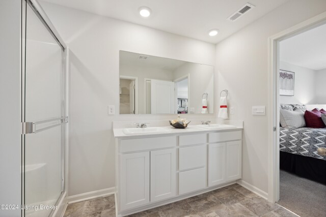 bathroom with a shower with door and vanity