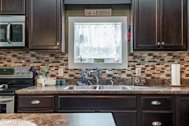 kitchen featuring dark brown cabinetry, sink, stainless steel appliances, and backsplash