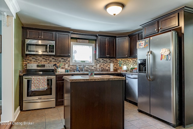 kitchen with tasteful backsplash, dark brown cabinetry, appliances with stainless steel finishes, and a center island